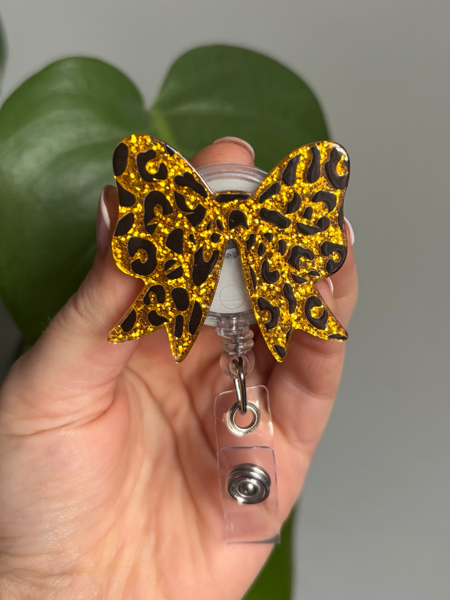 Golden leopard print retractable badge reel in a bow shape