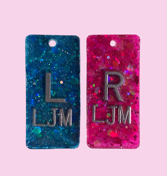 Blue and pink glitter X-Ray markers with initials